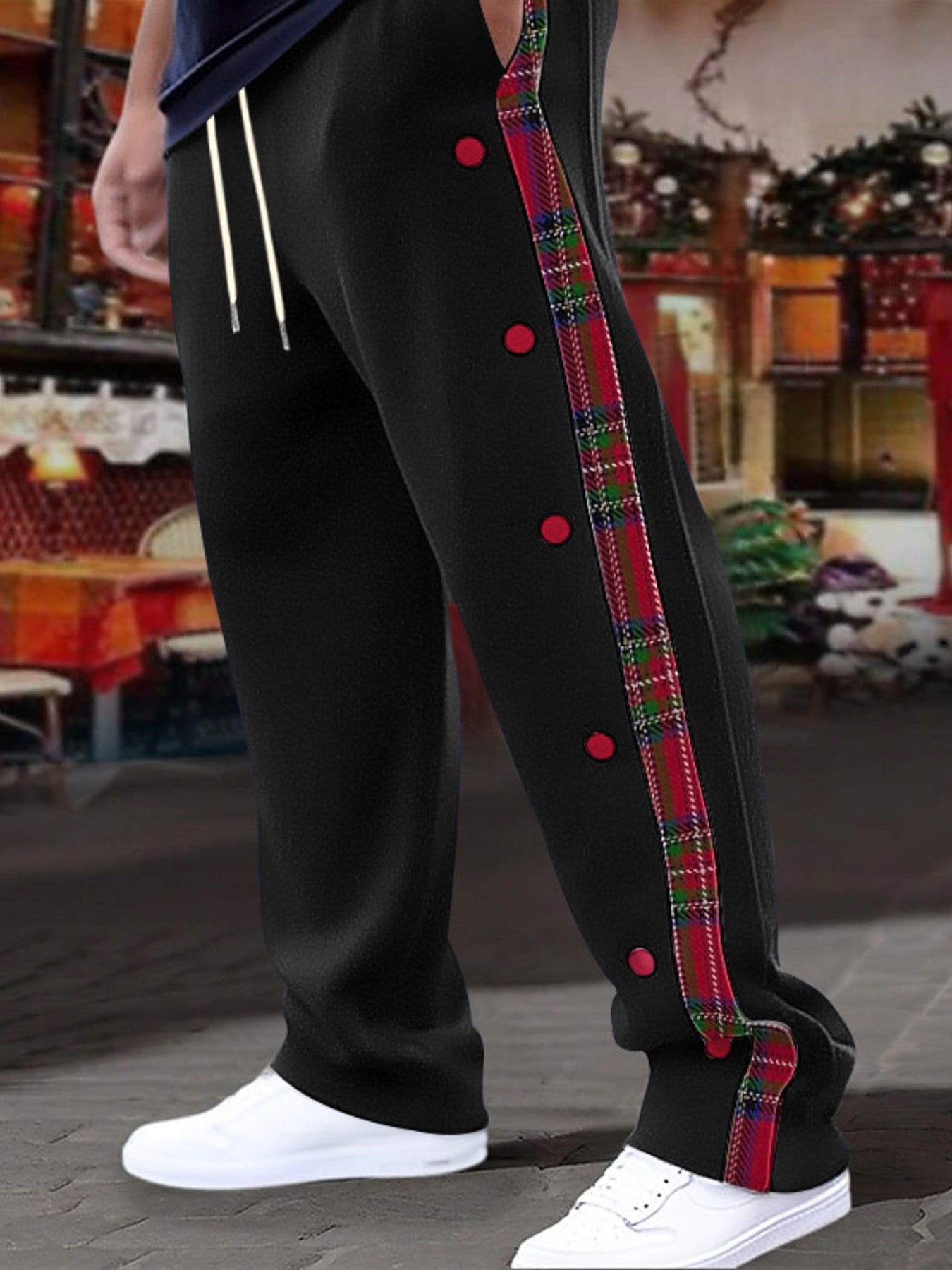 Black sweatpants with plaid snap-button trim and drawstring waist.