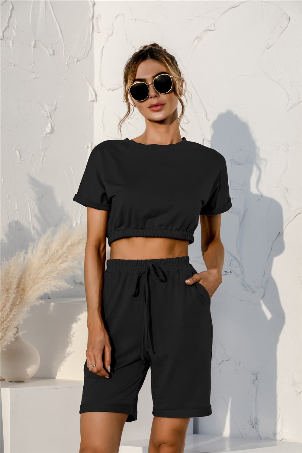 Black loungewear set with rolled sleeve crop top and drawstring shorts