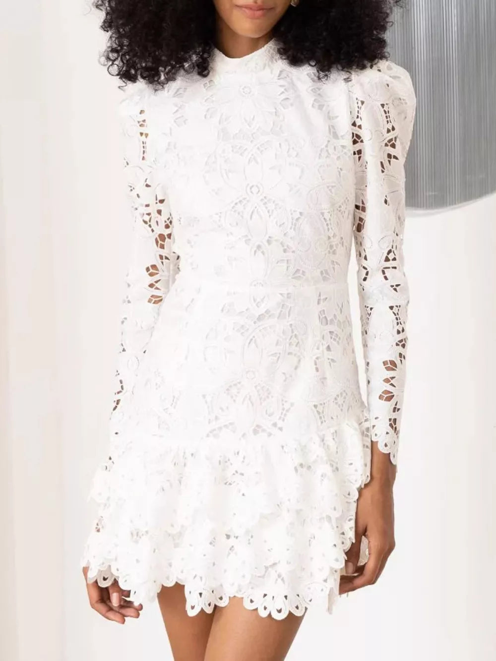 White lace mock neck mini dress with ruffled hem and puff sleeves.