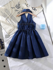 Dark blue denim baby dress with halter neckline, elastic waist, and pleated skirt.