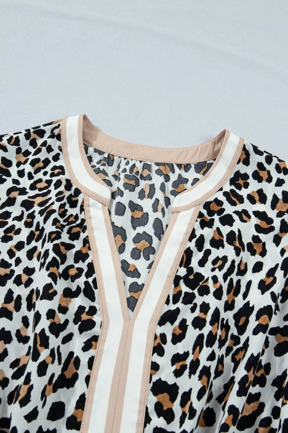 Leopard print midi dress with V-neck and colorblock trim detail.