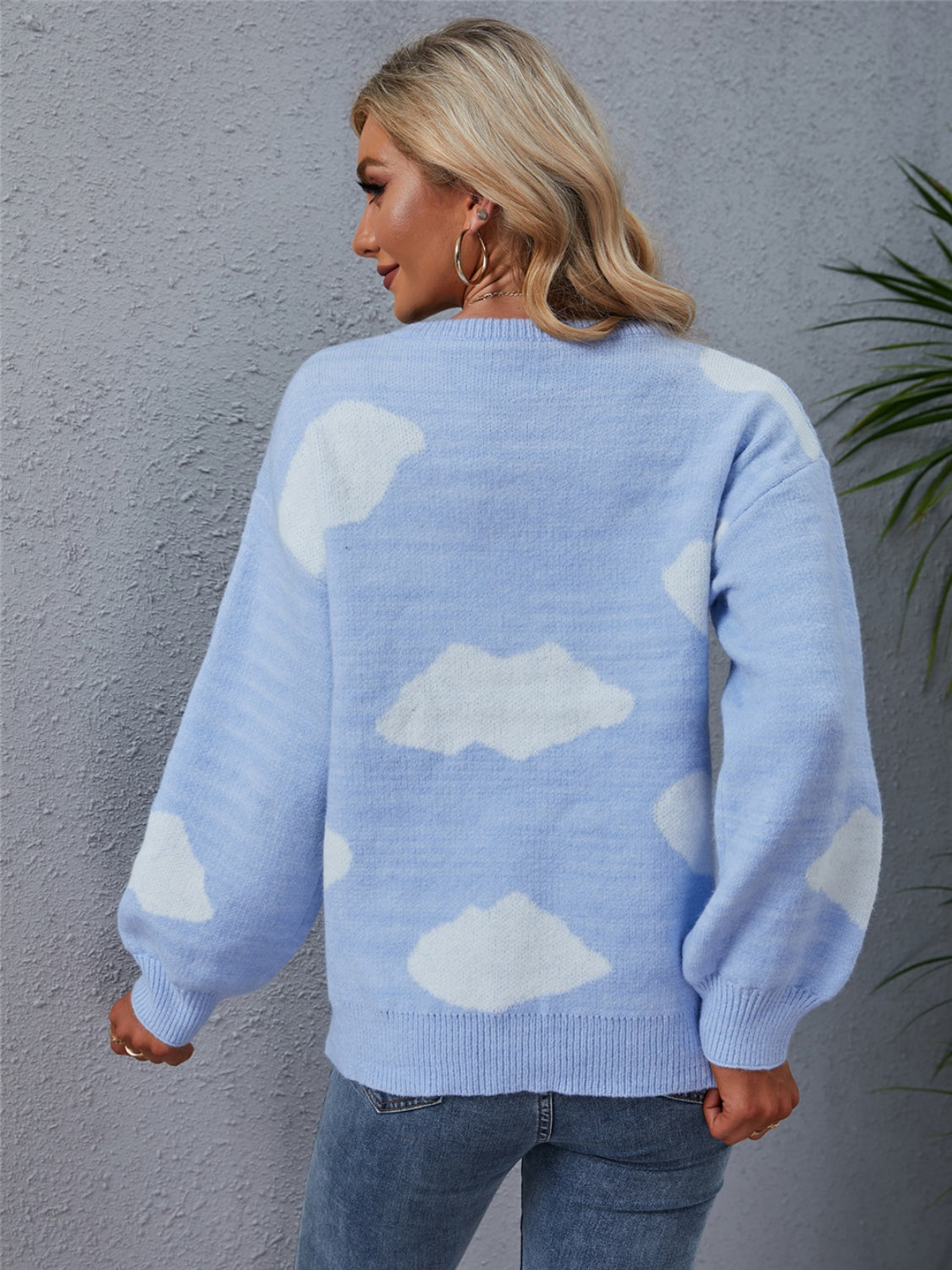 Light blue acrylic sweater with white cloud intarsia pattern, crew neck, and balloon sleeves.