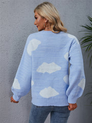 Light blue acrylic sweater with white cloud intarsia pattern, crew neck, and balloon sleeves.