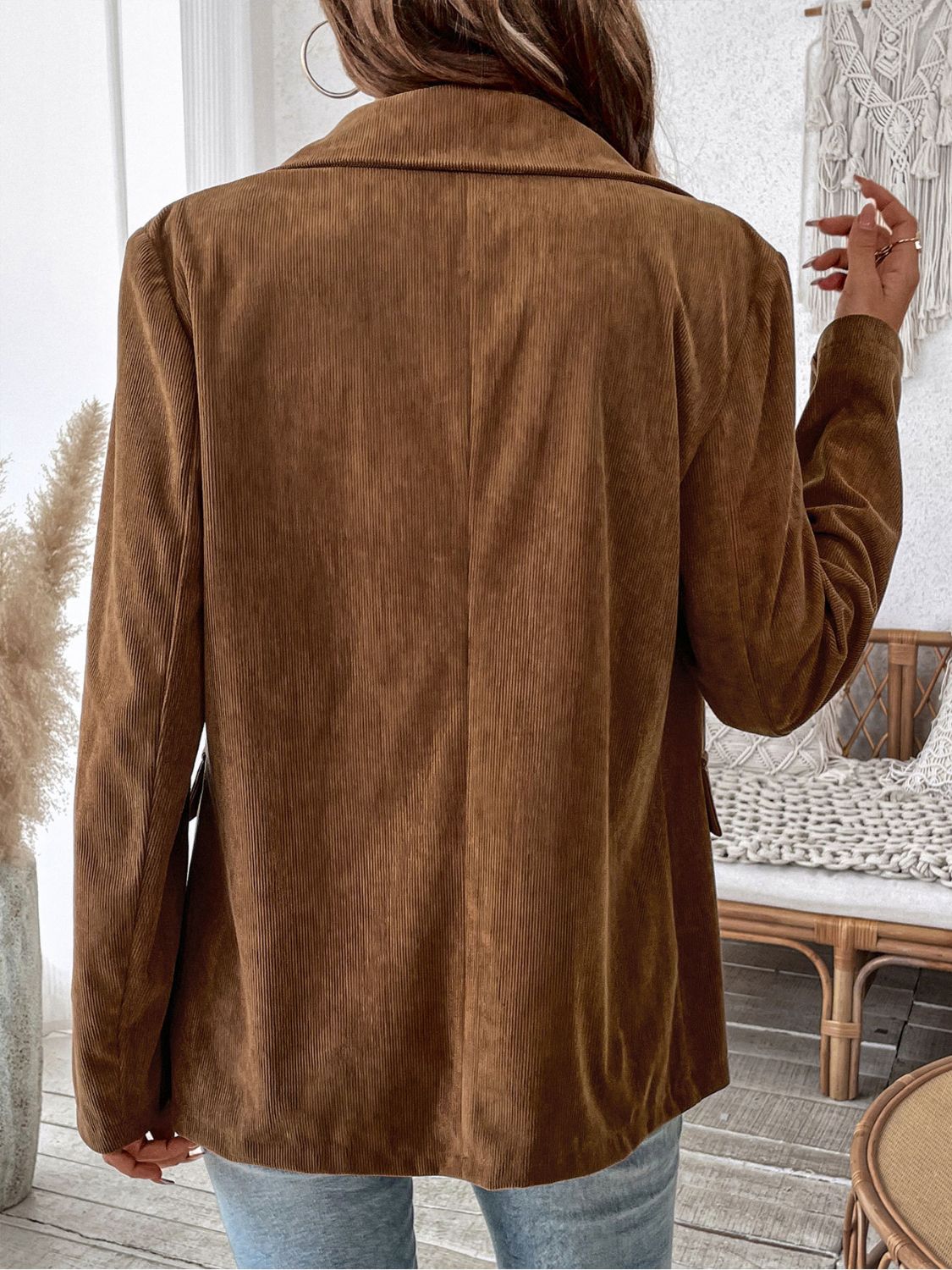 Brown corduroy double-breasted blazer with a classic collar and long sleeves.