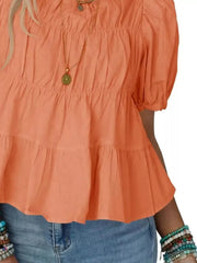 Orange maternity blouse with puff sleeves, ruffled tiers, and smocked bodice detail.