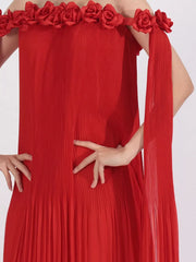 Red off-shoulder maxi dress with floral applique neckline and pleated fabric.