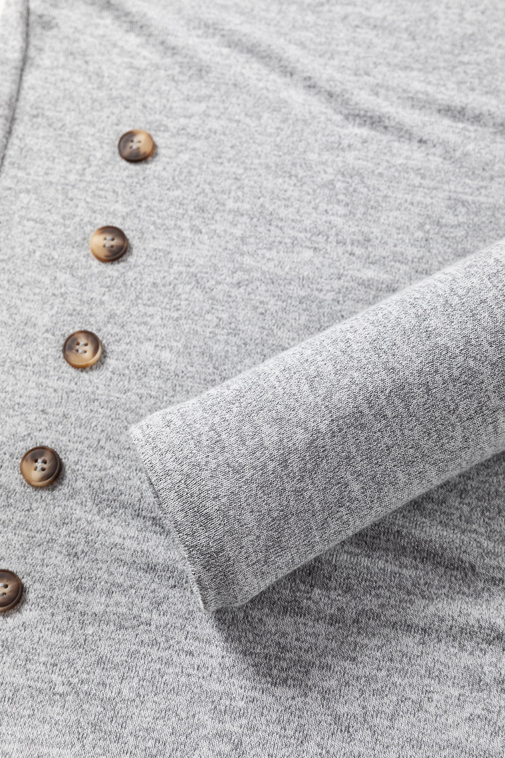 Dark gray slouchy knit top with side button detail and ribbed sleeve cuff.