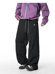 Relaxed fit black cargo pants with white drawstring and side zip pockets.
