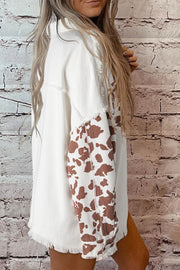 White cotton shacket with cow print sleeves and frayed edges.