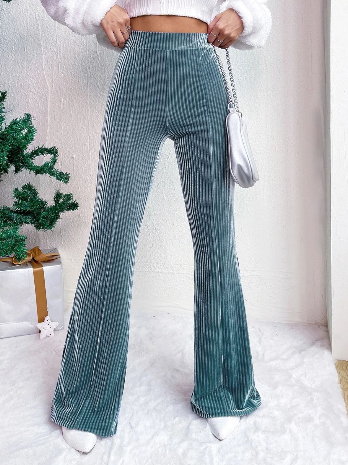 Teal corduroy bell bottom trousers with vertical ribbing and a flared leg.