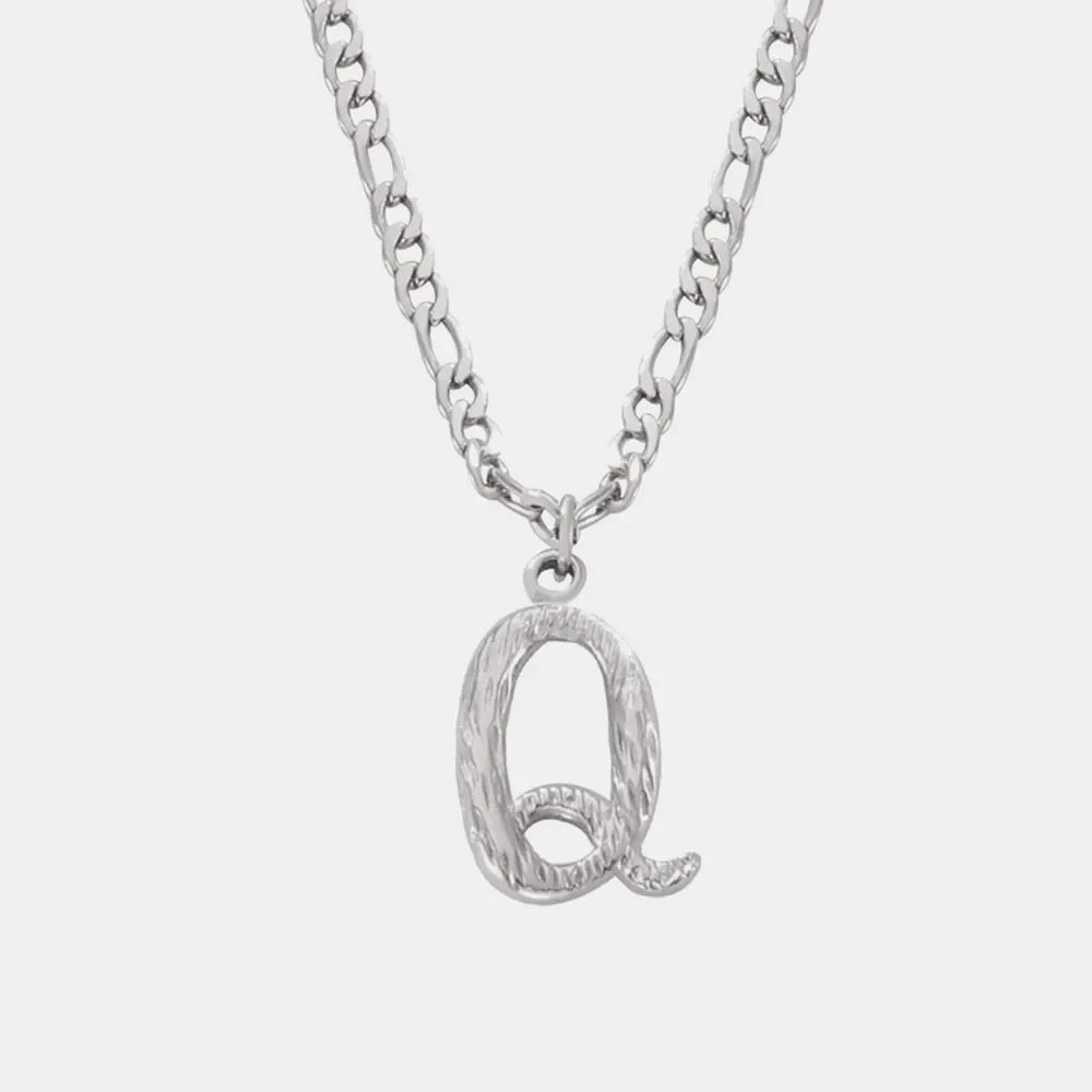 Silver initial pendant necklace with textured letter Q and curb chain.