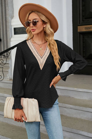 Black textured V-neck blouse with lace trim and smocked cuffs.