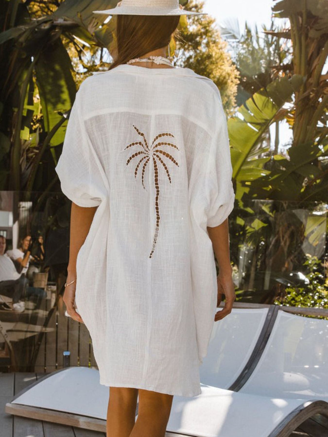 White cotton blend button-down shirt dress with palm tree cutout detail on back.