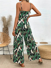 Botanical print cami jumpsuit in dark green with wide legs and spaghetti straps.