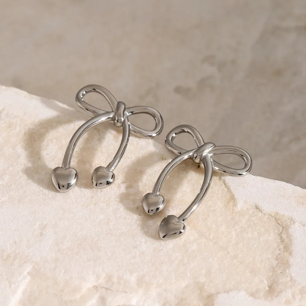 Silver bow drop earrings with heart charms