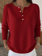 Red buttoned long-sleeve knit top with a henley neckline.