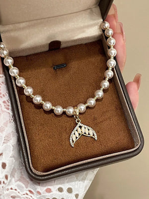 Pearl choker necklace with gold mermaid tail pendant and crystal accents