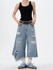 Distressed wide-leg jeans with raw hem and ripped details.