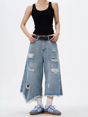Distressed wide-leg jeans with raw hem and ripped details.