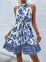 Floral print halter dress with tie waist and ruffled hem in royal blue.