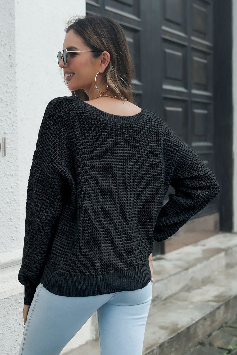 Black waffle knit acrylic sweater with crew neck and long sleeves.