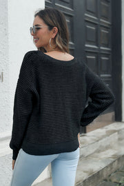Black waffle knit acrylic sweater with crew neck and long sleeves.