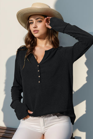 Black waffle knit henley shirt with thumbhole cuffs and button placket.