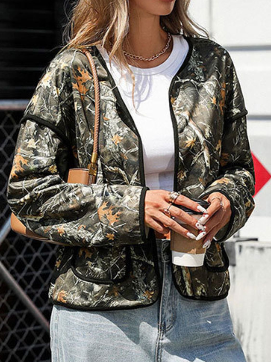 Multicolor camouflage print open jacket with black trim and pockets.