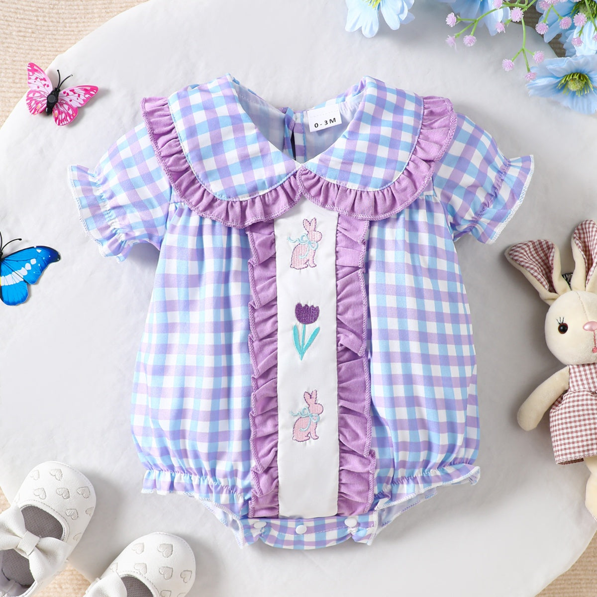 Baby one-piece with purple and blue gingham, ruffle collar, and embroidered bunnies and tulip.