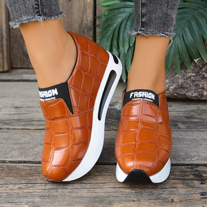 Brown crocodile pattern slip-on flats with chunky white soles and "Fashion" detail.