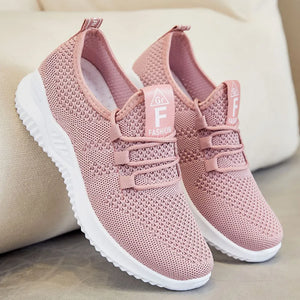 Pink knit runner sneakers with white soles and logo detail on tongue.