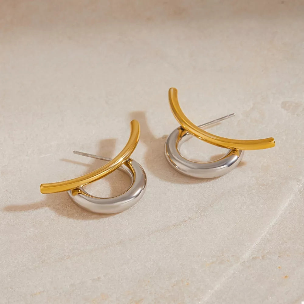 Intertwined two-tone C-hoop earrings with gold and silver metal accents.