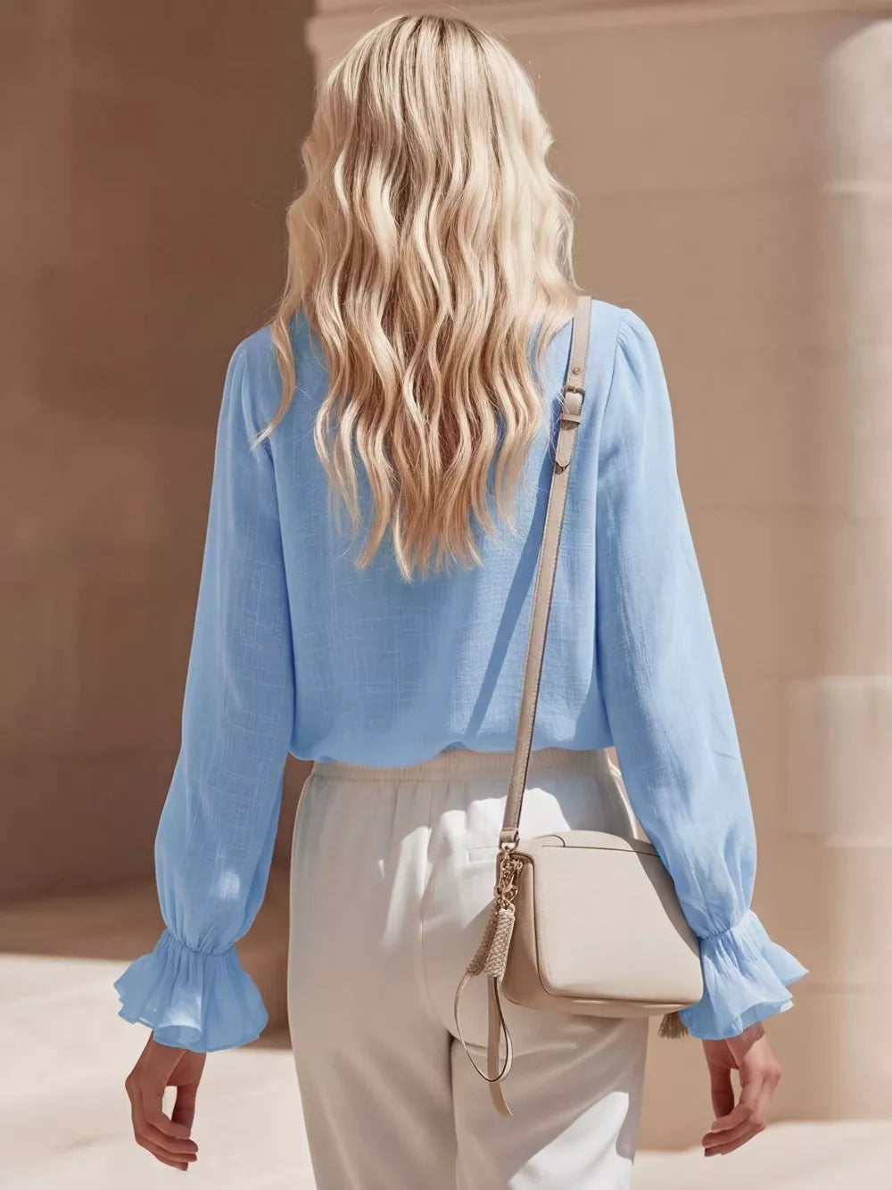 Sky blue maternity shirt with ruffled V-neck and long sleeves.