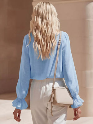 Sky blue maternity shirt with ruffled V-neck and long sleeves.