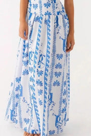 Light blue and white patterned maxi dress with a flowing skirt and ruched detail.