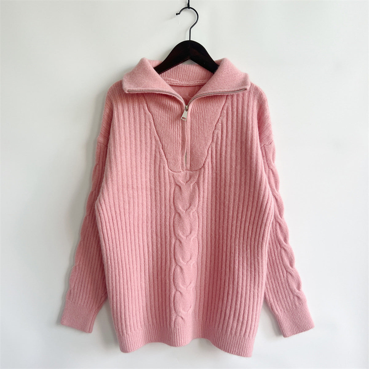 Dusty pink cable knit zip-neck sweater with ribbed texture and braided detail.