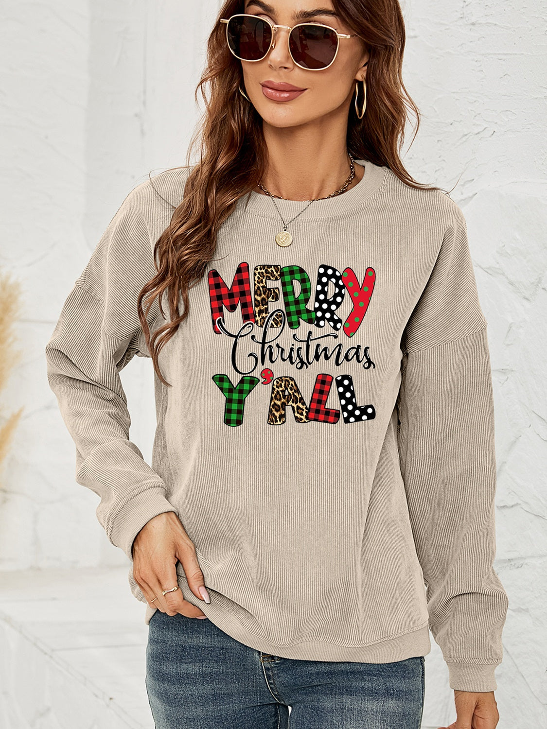 Beige corduroy sweatshirt with "Merry Christmas Y'all" graphic in plaid, leopard, and polka dot patterns.