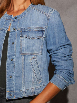 Light wash denim utility jacket with band collar, chest pocket, and button front.
