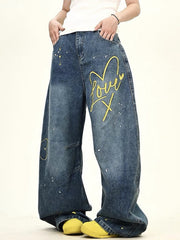 Oversized blue wide-leg jeans with yellow love heart graphic and paint splatters.