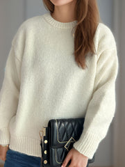 Oversized cream crewneck sweater with textured knit and ribbed cuffs.