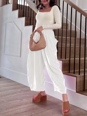White linen balloon trousers with cargo pockets and drawstring waist.