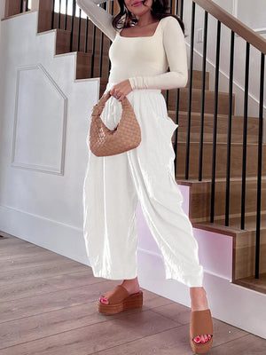 White linen balloon trousers with cargo pockets and drawstring waist.