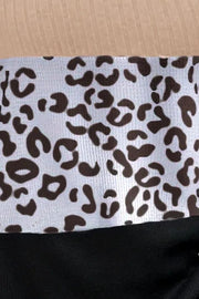 Colorblock leopard print ribbed knit top with a tan ribbed neckline and black hem.