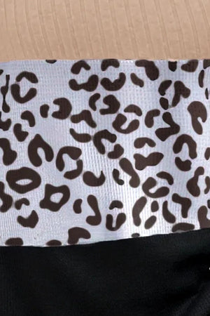 Colorblock leopard print ribbed knit top with a tan ribbed neckline and black hem.