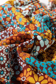 Floral patchwork culotte jumpsuit with a retro floral print in rust, yellow, and teal.