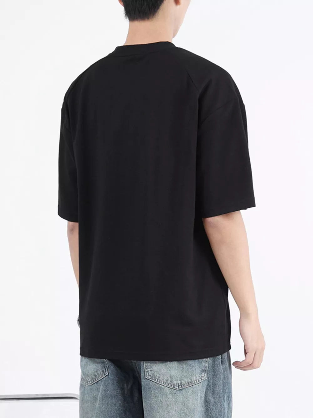 Black cotton t-shirt with round neck and short sleeves, shown from the back.