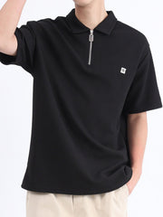 Black textured polo shirt with short sleeves and a zipper detail