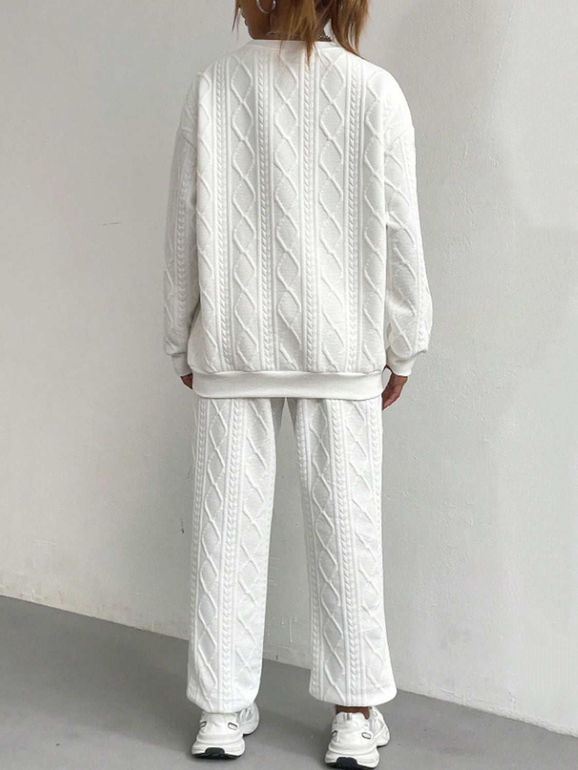 White cable knit loungewear set with crewneck sweatshirt and wide leg pants.