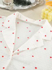 White cotton button-down pajamas with red heart print and textured fabric.