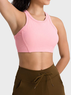 Ribbed blush pink racerback crop top with contour stitching and a rounded neckline.